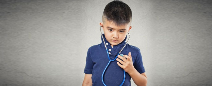 a little boy listening to his heart with stethoscope