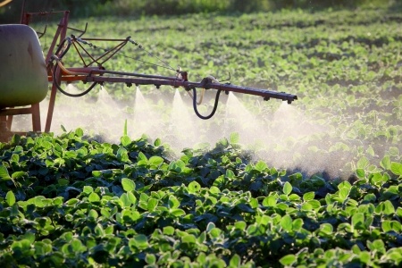 machine spraying pesticides on crops